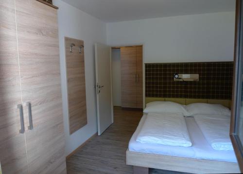 Dormitorio pequeño con cama y armario en Ferienwohnung Loitfelder-Pang, en Saalbach Hinterglemm