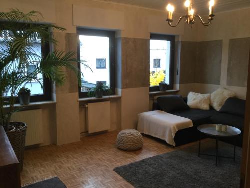 a living room with a couch and two windows at Ferienwohnung Beletage mit Terrasse in Neuwied