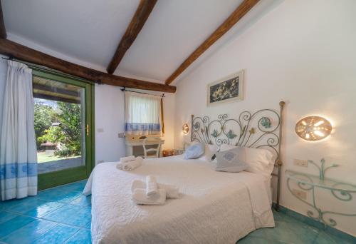 a bedroom with a white bed with towels on it at Villa Lumaca in Porto Rotondo