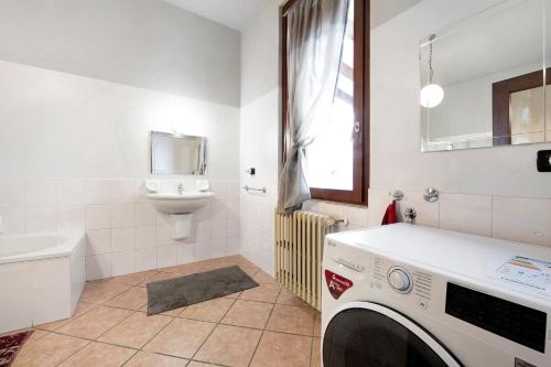 a bathroom with a washing machine and a sink at Wakesurfhouse in Sulzano