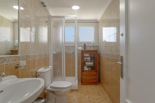 a bathroom with a toilet and a sink and a shower at Céntrico apartamento en Tarifa in Tarifa
