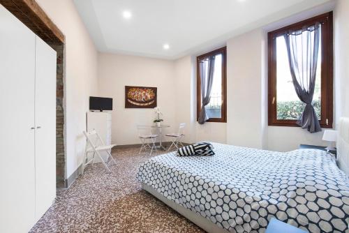 a bedroom with a bed and two windows at Wakesurfhouse in Sulzano