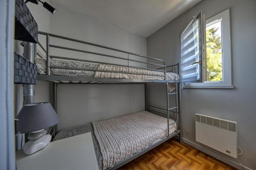 two bunk beds in a room with a window at Maisonnette Botticelli - Ares in Arès