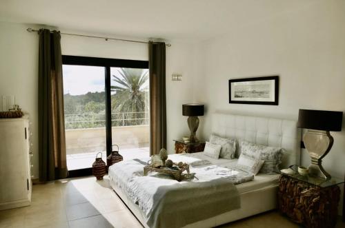a bedroom with a large bed and a large window at Ocean Blues in Cala Santanyi
