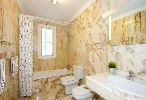 a bathroom with a toilet and a sink and a tub at Villa Benedicte in Puerto del Carmen