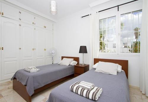 two beds in a room with white walls and windows at Villa Benedicte in Puerto del Carmen