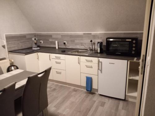 a small kitchen with a sink and a microwave at Ferienwohnung Conrads in Zetel