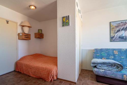 a small bedroom with a bed and a couch at Grand Hotel Studio in Valras-Plage