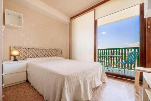 ein Schlafzimmer mit einem Bett und einem großen Fenster in der Unterkunft Mirador Altafulla in Altafulla