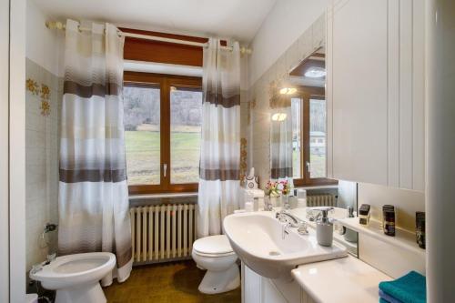 a bathroom with a sink and a toilet and a window at Casa Vacanze Gianluca in Aosta