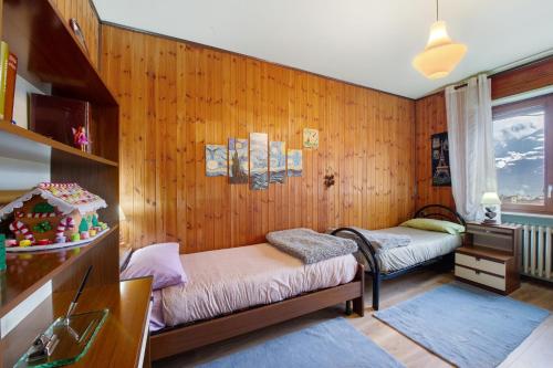 a room with two beds in a wooden wall at Casa Vacanze Gianluca in Aosta