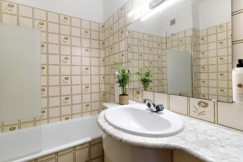 a bathroom with a sink and a mirror at Retro Beach House Moledo in Moledo