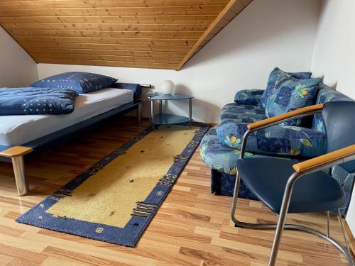 a room with a bed and a couch and a chair at Ferienwohnung Heilsbronn in Heilsbronn