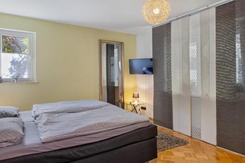 a bedroom with a bed and a flat screen tv at Ferienwohnung Fuldatalblick in Fulda