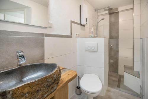 a bathroom with a sink and a toilet at Ferienwohnung 9 und 40 in Thunum