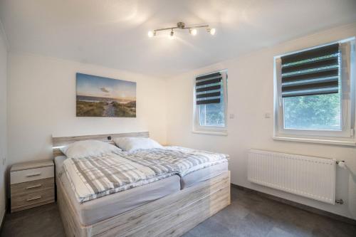 a bedroom with a large bed and two windows at Ferienwohnung 9 und 40 in Thunum