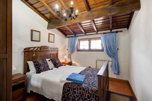 a bedroom with a large bed with blue sheets at Azenha da Lagoa Negra in Barqueiros