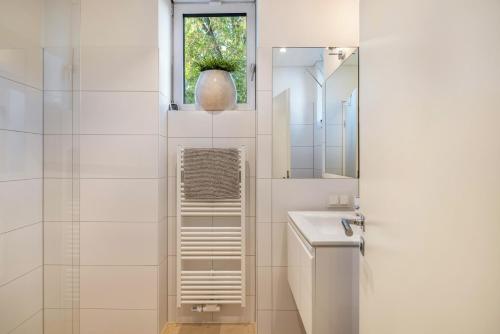 a white bathroom with a sink and a mirror at Ferienwohnung Ederweg in Wahlershausen