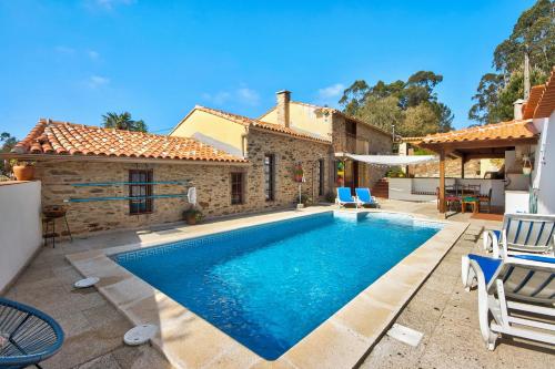 a villa with a swimming pool in front of a house at Azenha da Lagoa Negra in Barqueiros