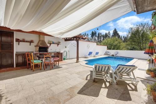 a patio with a table and chairs and a swimming pool at Azenha da Lagoa Negra in Barqueiros