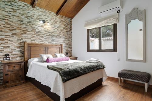 a bedroom with a large bed and a brick wall at Villa Africa in La Muela