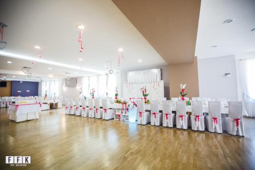 a large room with white chairs and tables and white tables and chairs at Pałac Pawłowice in Gorz
