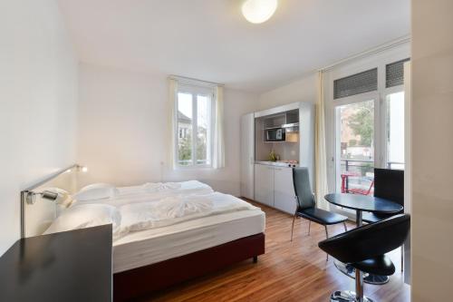 a bedroom with a bed and a table and chairs at Swiss Star California - Self Check-In in Zurich