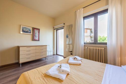 a bedroom with a bed and a dresser and a window at Casa Vacanze Matisse in Toscolano Maderno