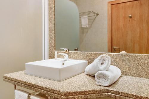a bathroom with a white sink and a mirror at Dfm Happy Days C - Funchal in Funchal