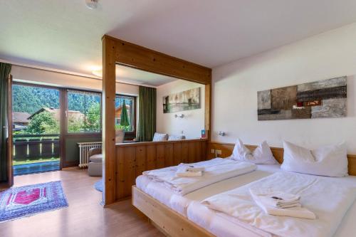 a bedroom with a large bed with white sheets at Studio Bergblick in Inzell