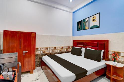 a bedroom with a bed and a table and a chair at Super Hotel O Raj Ghat Ayodhya Formerly Shree Siya Raman in Ayodhya