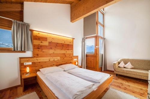a bedroom with a bed with a wooden wall at Ferienwohnung Burgeis in Malles Venosta