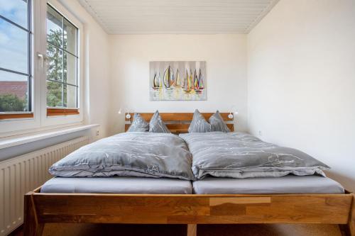 a bedroom with a wooden bed with pillows and a window at Ferienwohnung Kropp in Knorrendorf