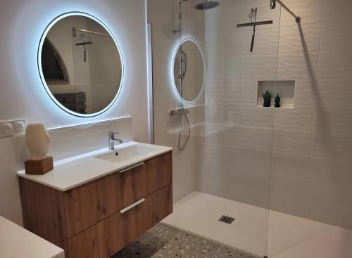 a bathroom with a sink and a shower with a mirror at Chambre D'hôtes À 2 Pas Des Plages in Notre-Dame-de-Riez
