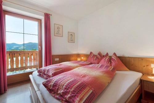 a bedroom with a bed with a large window at Stinerhof Panoramablick in Vols am Schlern