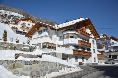 a large building in the snow with a mountain at Apart Birgit in Kappl
