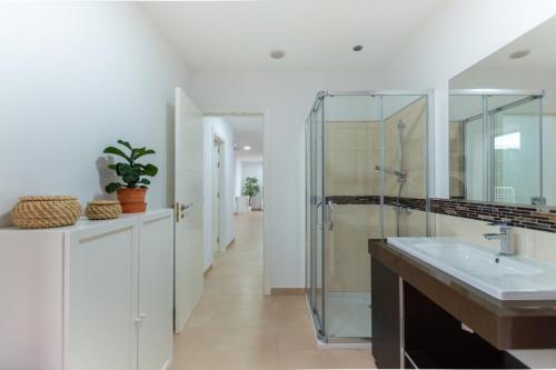 a bathroom with a sink and a glass shower at Eclipse in Puerto del Rosario