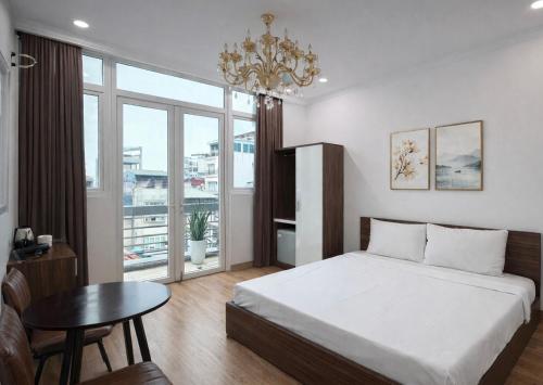 a bedroom with a bed and a table and a window at Dreamora Centre Hotel in Hanoi