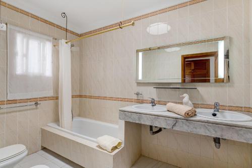 a bathroom with a sink and a tub and a toilet at Casa Colleen in Puerto del Carmen