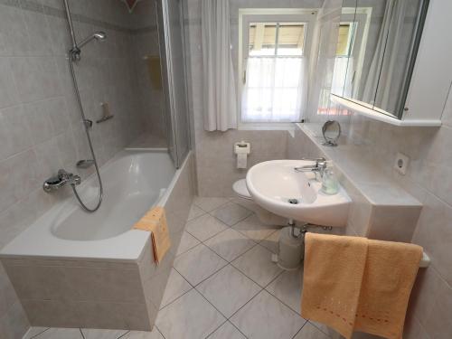 a bathroom with a tub and a sink and a toilet at Ferienwohnung Haus Doris in Rickenbach