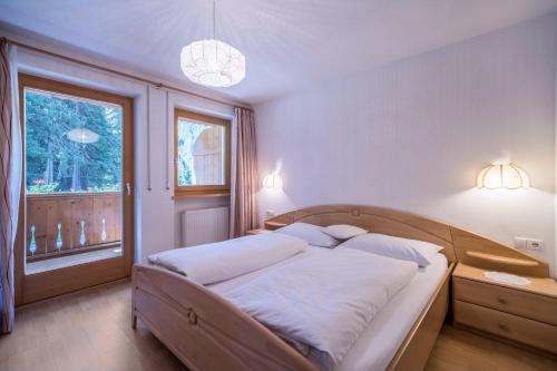 a bedroom with a large bed with white sheets and a window at Ferienhaus Maria Arnika in Moso
