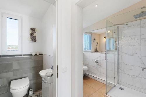 a white bathroom with a toilet and a shower at Feriendomizil Bergamini in Bischoffingen