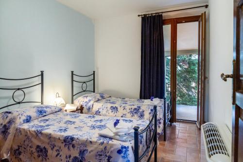 a bedroom with two beds with blue and white sheets at Capracotta - Alba in Montemassi