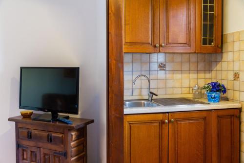 a kitchen with a sink and a flat screen tv at Capracotta - Alba in Montemassi