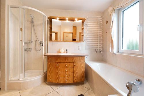 a bathroom with a tub and a sink and a shower at Ferienwohnung Baier in Überlingen