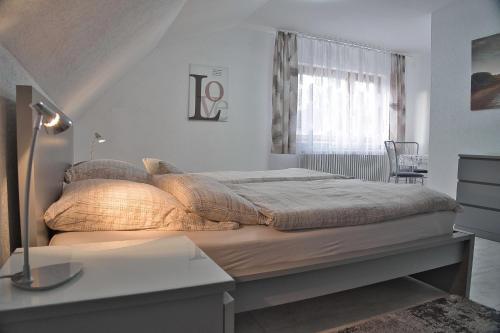 a bedroom with a bed with a lamp and a window at Kunibert, 120 qm in Stockach