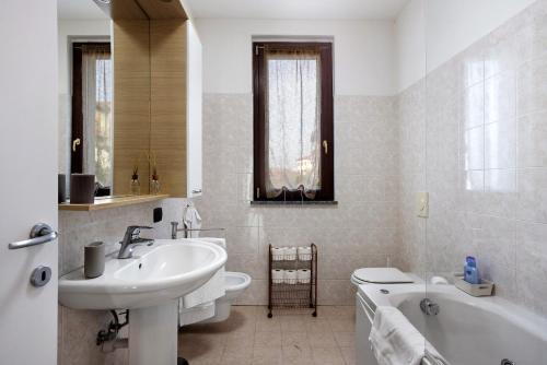 a bathroom with a sink and a tub and a toilet at vb home brianza in Costa Masnaga