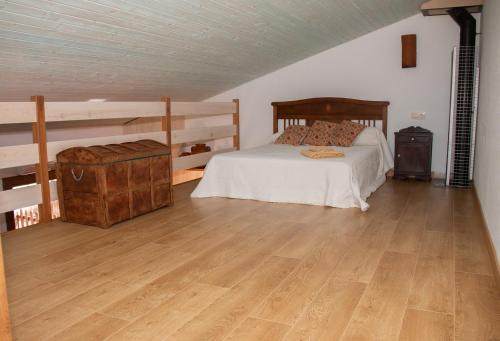 a bedroom with a bed and a wooden floor at Casa Mariano in Turégano