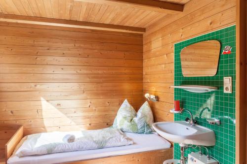 a bathroom with a green tiled wall and a sink at Ferienwohnung Oberangerhof in Kaltenbach
