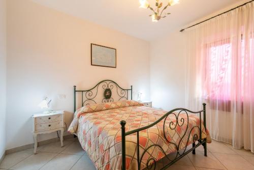 a bedroom with a bed and a table and a window at Papà Giuseppe La Stalla in Cortona
